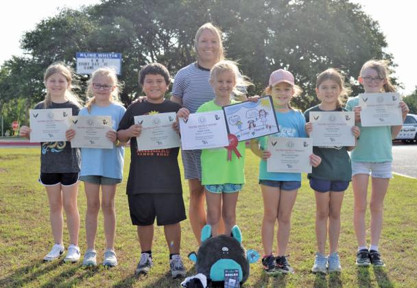 Erick Mitchell | dispatch record Kline Whitis Elementary students acknowledged for their participation in the annual Rabies Awareness &amp; Prevention Poster Contest include, from left, Ava Latham, Keira Sladek, Rhett Perez, Arden Achèe, Kylee Jean Kruppa, Caroline Jones and Kylee Davis. Assistant Principal Tracie Chapa stands behind the group.