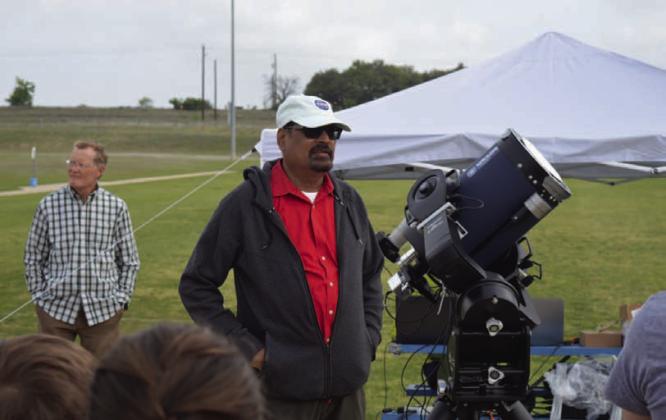 ERICK MITCHELL | DISPATCH DISPATCH NASA scientists Dr. Natchimuthuk “Nat” Gopalswamy speaks with eclipse chasers at the 580 Sports Park prior to the 2024 total solar eclipse. Also pictured is one of the telescopes NASA scientists used to study the eclipse.