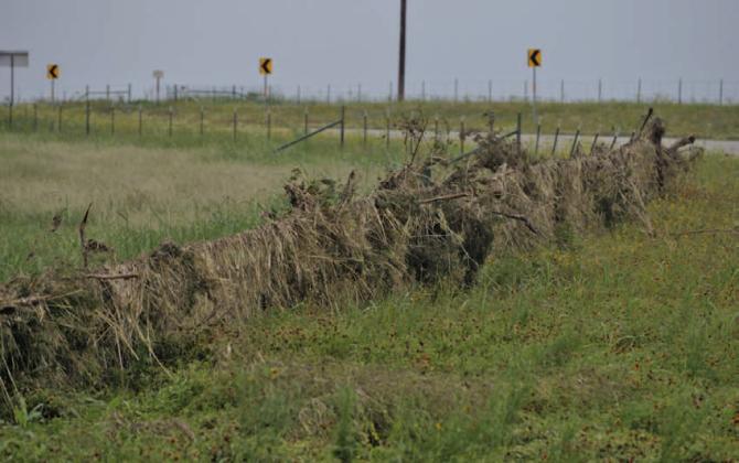 ERICK MITCHELL | DISPATCH DISPATCH Lost hay from the Cinco De Mayo flood can be seen along this damaged fence line on Farm to Market Road 1690.
