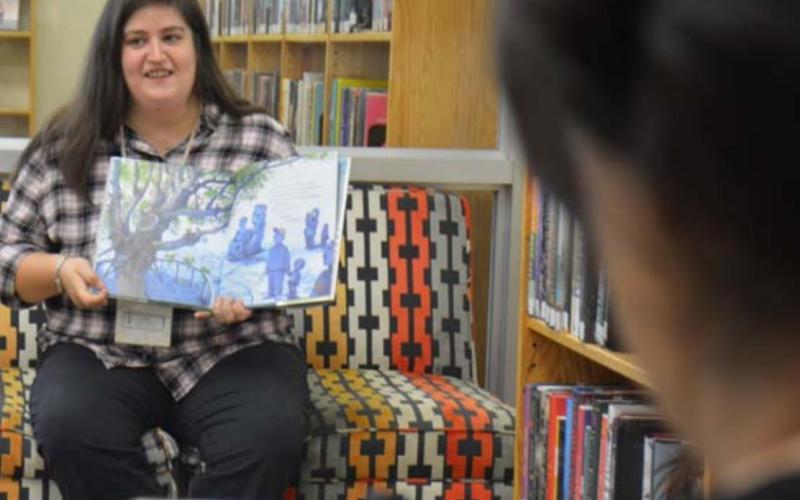 Assistant Librarian Emily Stone reads “This Very Tree” by Sean Rubin, while Library Clerk Sammi McKenzie livestreams on her phone during the weekly storytime Wednesday morning at the Lampasas Public Library. MONIQUE BRAND | DISPATCH RECORD