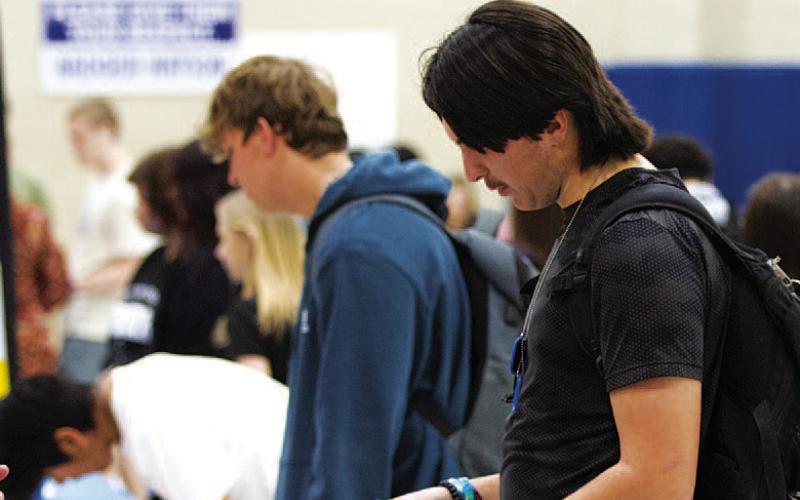 Jonathan Harris scans a flier during the LHS Job Fair. The fair allowed students to learn about careers and jobs available in the Lampasas community. HUNTER KING | DISPATCH RECORD