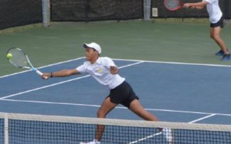 Mario Aguirre hits the ball near the net while Sam Zmolik plays the baseline in the boys’ doubles quarterfinals match at regionals. KENNETH PEISER | COURTESY PHOTO