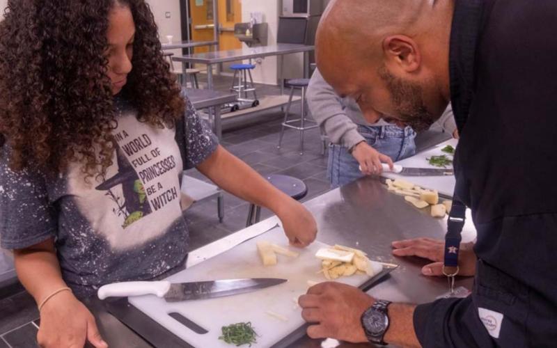 Chef Jason Walsh instructs Brigae Wooten on proper culinary presentation techniques. MICHAEL CUVIELLO | DISPATCH RECORD