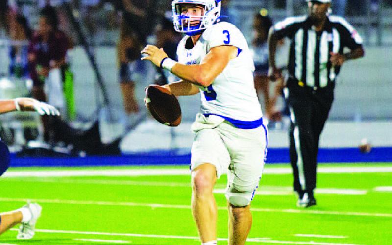 Reed Jerome rolls to his left and looks for a receiver during last Friday’s game. HUNTER KING | DISPATCH RECORD
