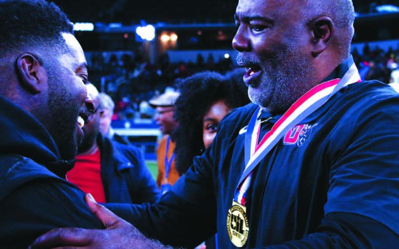 Duncanville head coach Reginald Samples, right, is embraced by his son, Rashaad, after winning a state title. MASON HINES | DISPATCH RECORD