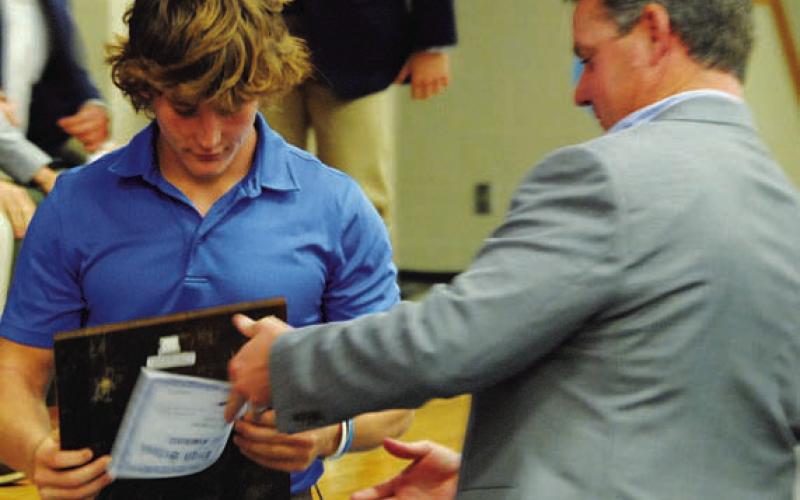 Reed Jerome receives his award from head coach Troy Rogers. HUNTER KING | DISPATCH RECORD