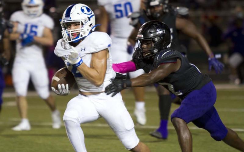 Ethan Moreno runs away from an LBJ defender during last Friday’s district game in Austin. HUNTER KING | DISPATCH RECORD