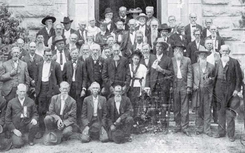 A group of Confederate veterans lined up for the camera on the south side entrance to the Lampasas County Courthouse. Instead of gray uniforms, many of the old men wore gray beards. Date of the photo is unknown. keystone square museum files