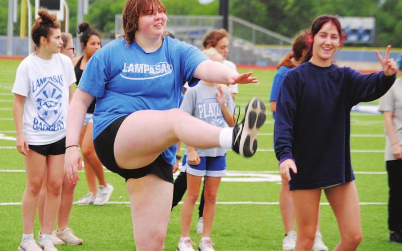 Morgan Lovejoy, left, and Peyton Tatum work through some warmup exercises before starting to run. HUNTER KING | DISPATCH RECORD