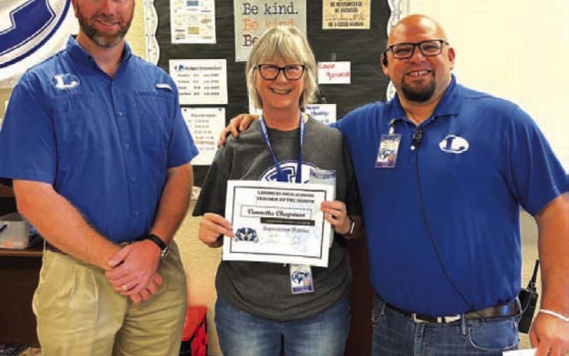 Lampasas High School honored Vannetta Chapman as its Teacher of the Month for September. The English teacher is also an accomplished author. “She does an amazing job building relationships with her students to promote high-level thinking,” said Assistant Principal Ryan Race, pictured at right. Also on hand for the recognition was Clay Phillips of Texas Farm Bureau Insurance. COURTESY PHOTO