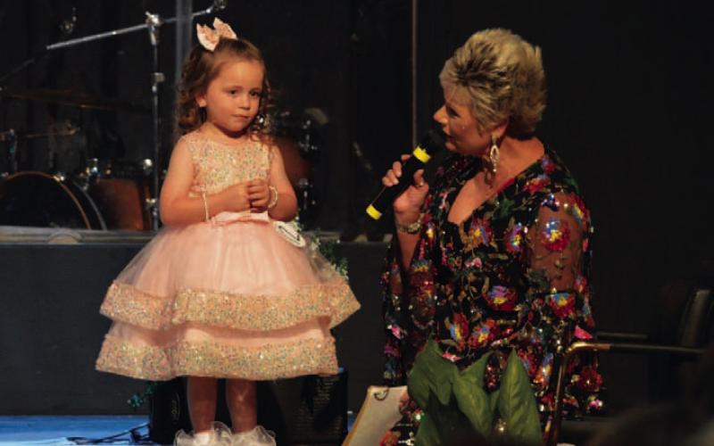 Litte Miss Spring Ho runner-up Berkley Shuffler awaits a question during her pageant interview with master of ceremonies Alicia Straley on Monday evening. ERICK MITCHELL | DISPATCH RECORD