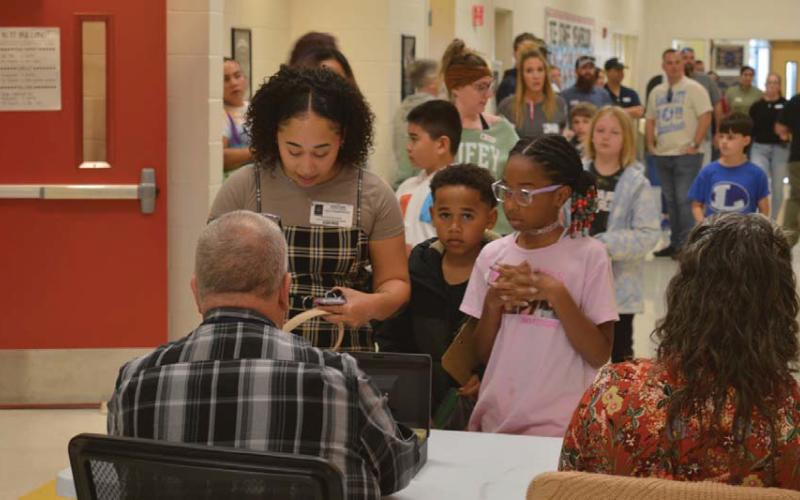 Taylor Creek Elementary School parents and children wait in line to check in for Friday’s Thanksgiving celebration. erick mitchell | dispatch record