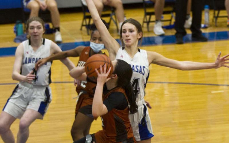 Addison McDonald, right, blocks a Hutto shot while senior teammate Taylor Allen (far left) helps on defense. JEFF LOWE | DISPATCH RECORD