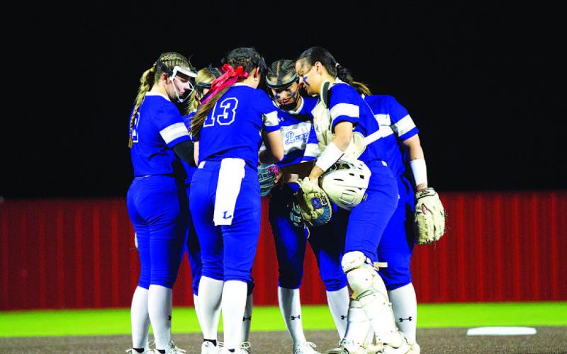 HUNTER KING | DISPATCH RECORD The Lady Badger infield gathers around the circle before the start of an inning.