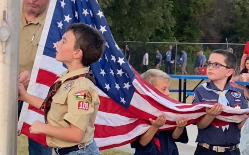Cub Scouts raise the flag at a recent Badger football game. Shown here, from left to right, are Scouts Camron St. John, Kannon Smith and Decil Stephen. Leader Larry Eddinger is in the background lending assistance. MARIAH CLARY | COURTESY PHOTO