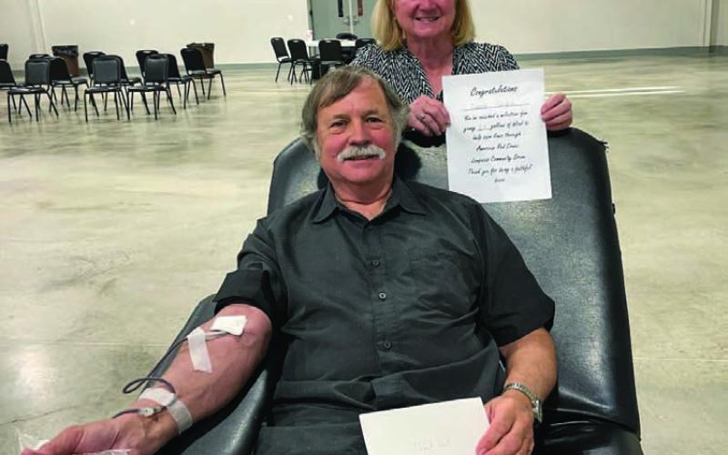 Clark Corbin is pictured making a blood donation, assisted by volunteer Janet Machen, at last week’s American Red Cross community drive. With his recent donation, Corbin has recorded a 23-gallon milestone to help save others in need of blood. COURTESY PHOTO