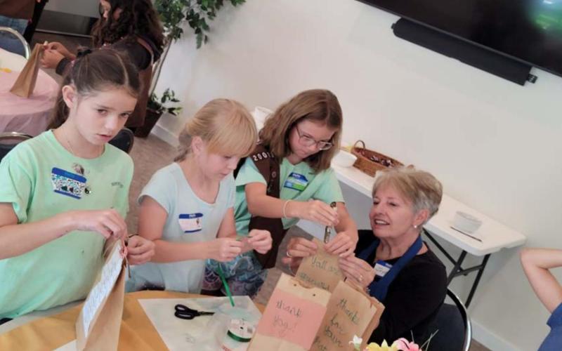 Assembling police survival kits before their delivery to the local department are Girl Scouts Emma-Lee Bull, Evelyn Peterson and Jenna Paige Linney, with adult helper Joyce Taylor. COURTESY PHOTO
