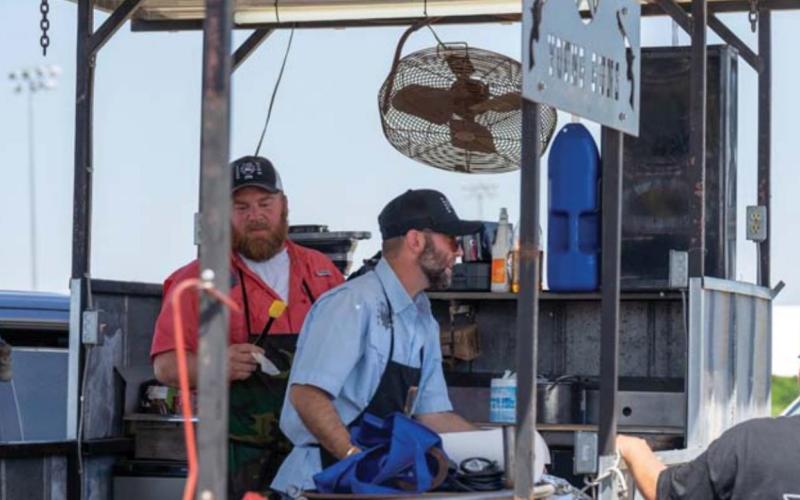 Matt Hendricks, left, and Joshua Smith get ready for the next competition at the LTX BBQ Fest in Lampasas. JEROMIAH LIZAMA | DISPATCH RECORD