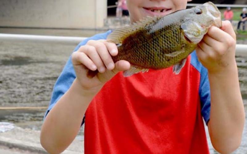 Bobby Chaney shows off his 8.5-inch catch. He tied at first place for longest catch in the 7- to 8-year-old division. MONIQUE BRAND | DISPATCH RECORD