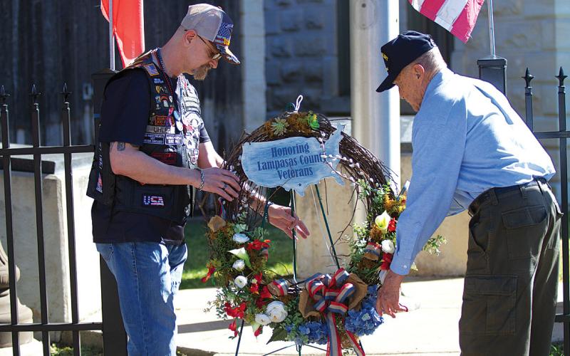 Sgt. Michael Uhler, at left, and former mayor and retired Col. Jack Calvert place a wreath at the Lampasas County Courthouse on Monday in honor of local veterans. Hunter King | dispatch record