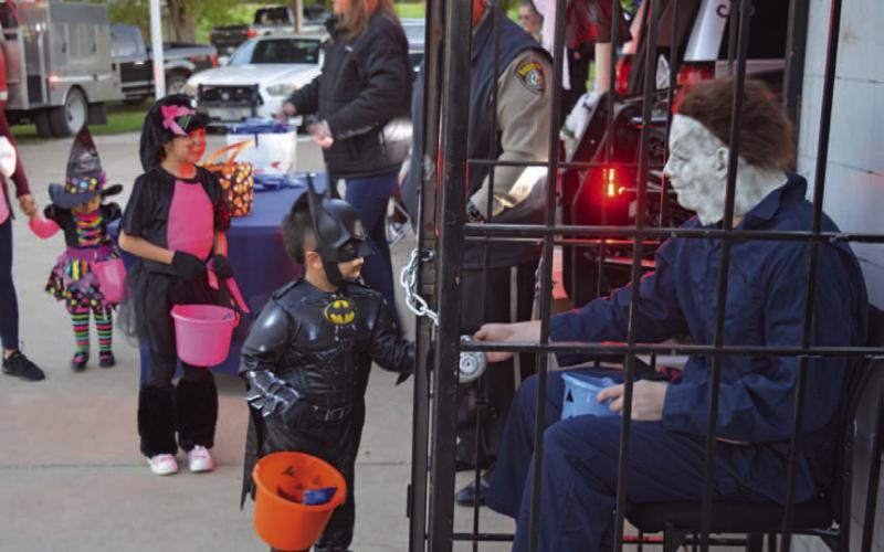 A young Batman receives candy from Michael Myers, dressed as an inmate of the Lampasas County Sheriff’s Office. The Kempner Volunteer Fire Department, Kempner Police Department and Hamilton EMS were all present for Kempner’s Halloween night event. ERICK MITCHELL| DISPATCH RECORD