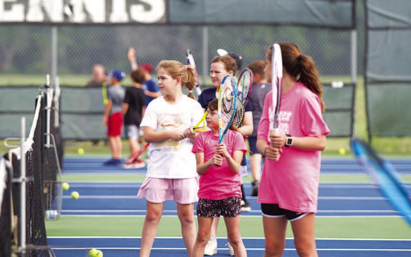 HUNTER KING | DISPATCH RECORD A group of young tennis players work on their volleys at camp on Tuesday.