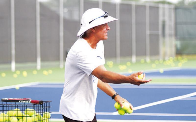 HUNTER KING | DISPATCH RECORD Kenneth Peiser flips balls to young players as he teaches them about forehands and backhands.