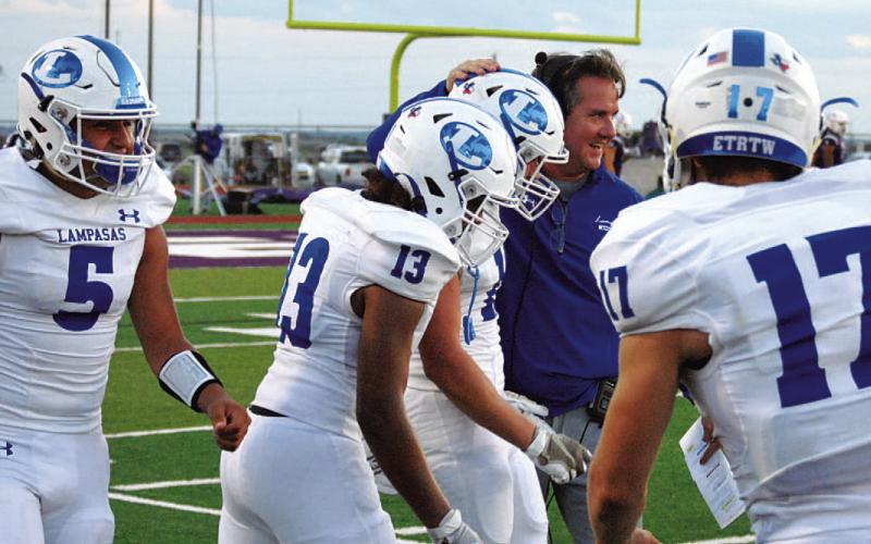 Head coach Troy Rogers smiles with Brock Langford after his 90-yard interception return. HUNTER KING | DISPATCH RECORD