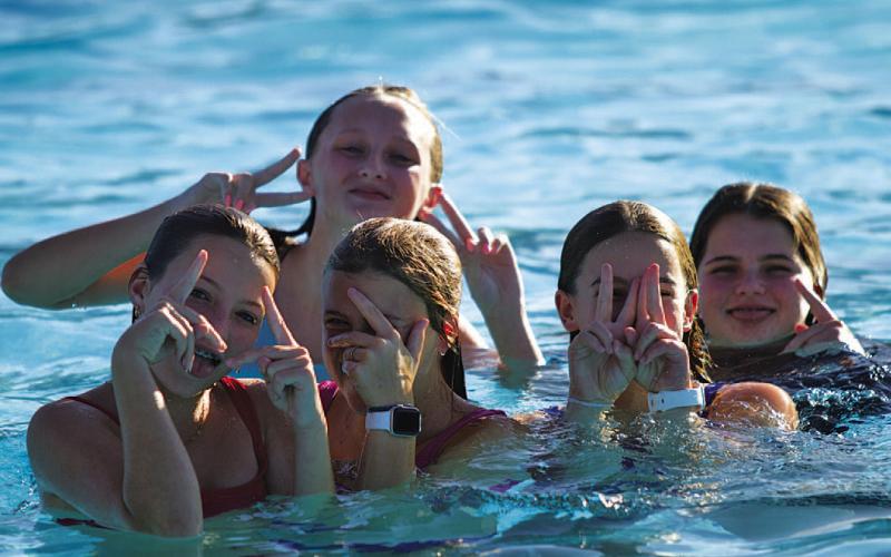 A group of middle school girls pose for a photo as they enjoy one of the final days of summer at the pool party. HUNTER KING | DISPATCH RECORD
