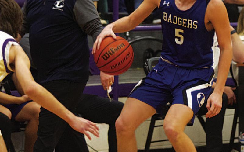 HUNTER KING | DISPATCH RECORD Trent Seneca dribbles down the court as head coach Aaron Nuckles looks on.