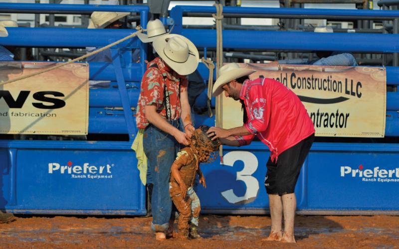 Patrick Sharp wipes himself off after taking a tumble in the mud during Friday’s mutton bustin’ competition at the Riata Roundup Rodeo. erick mitchell | dispatch record