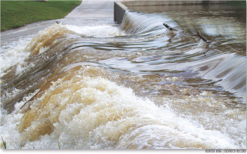 Water rushes over the cart bridge by the pro shop at Hancock Park Golf Course.