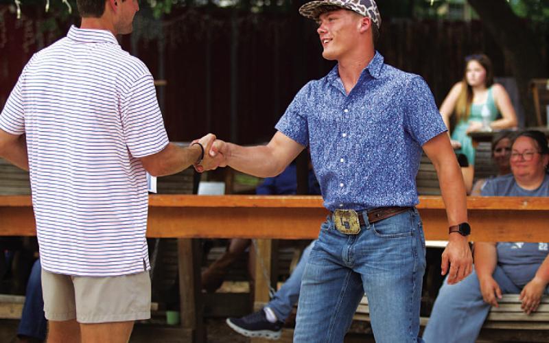 Corbin Kepler shakes the hand of coach Hadley Berry after receiving the Battlin’ Badger award. HUNTER KING | DISPATCH RECORD