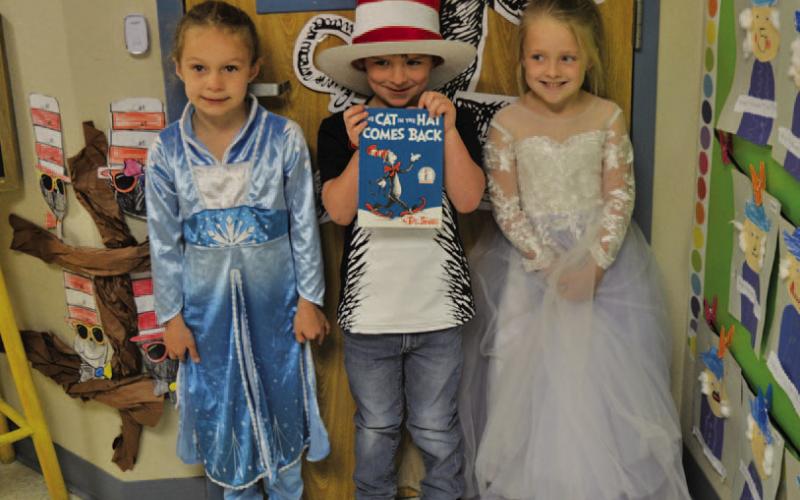Kindergarten students, left to right, Taylor Maudlin as Elsa, Layne Parker as Cat in the Hat and Harper Keefe as Cinderella pose as their favorite book characters. ERICK MITCHELL | DISPATCH RECORD