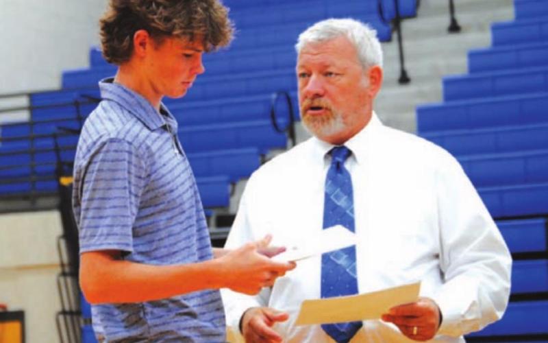Nate Borchardt receives his certificate from coach Justin Reeves. HUNTER KING | DISPATCH RECORD