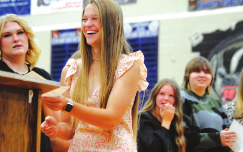 Senior Hadley Oncken laughs at a joke from coach Mark Myers as she gets an award Wednesday night. HUNTER KING | DISPATCH RECORD