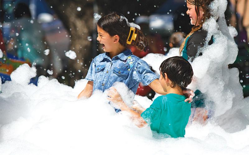 Gabriella Correia, left, and Jacob Correia play in the pit of foam outside the Lampasas Public Library on Friday morning. hunter king | Lampasas Dispatch Record