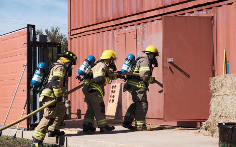 ADAM BARRIOS | DISPATCH RECORD Firefighters practice hose advancement and fire suppression as they enter the training building behind the Lampasas Fire Station. The all-day Saturday session offered a controlled environment in which firefighters from across Lampasas County could collaborate and hone their skills to be better prepared for emergencies that might arise.