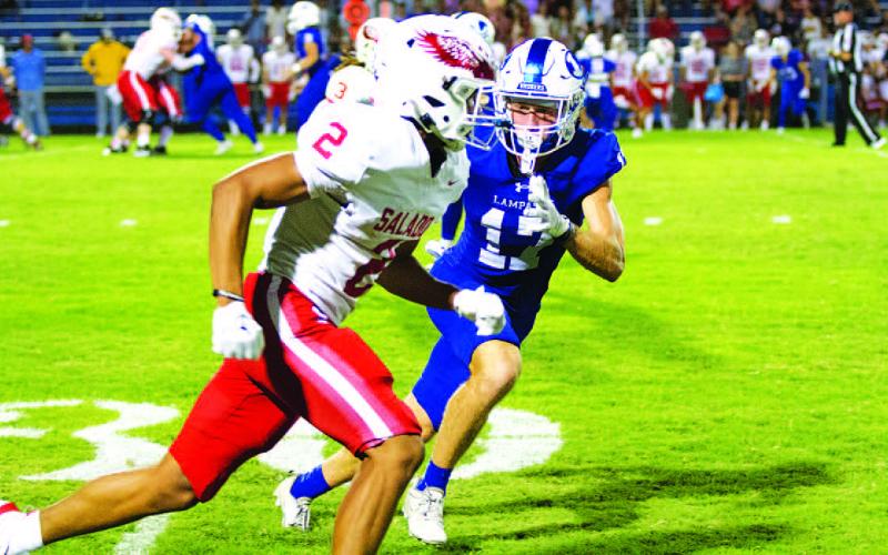 Sean Smith runs with an Eagle receiver during last week’s contest. HUNTER KING | DISPATCH RECORD