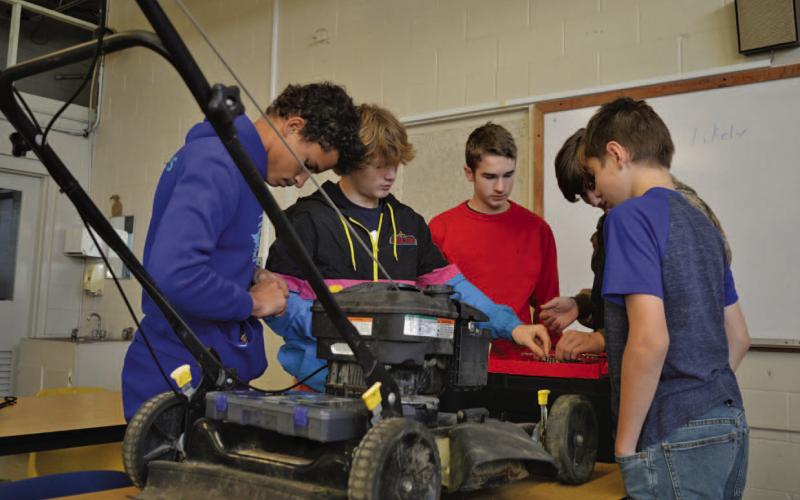 Lampasas Middle School students work on running diagnostics with a lawnmower Friday morning during their small-engines class. ERICK MITCHELL | DISPATCH RECORD