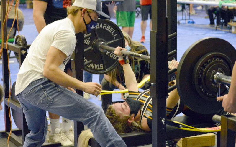 Alyssa Ayers bench presses, while her brother Jason Ayers spots her.