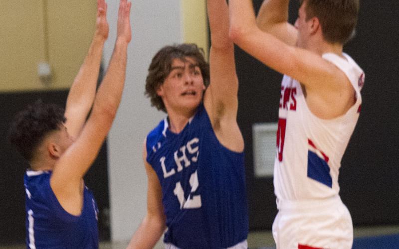 Landon Mulcahy and Anthony Ortiz defend against an outside shot.