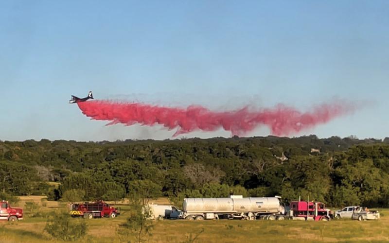 A single-engine air tanker drops Phos-Chek or slurry on the Spotted Opossum Fire to suppress the flames