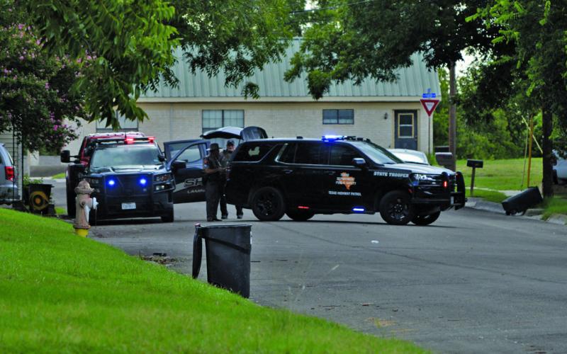 Lampasas Police and Texas DPS vehicles can be seen on a city block.