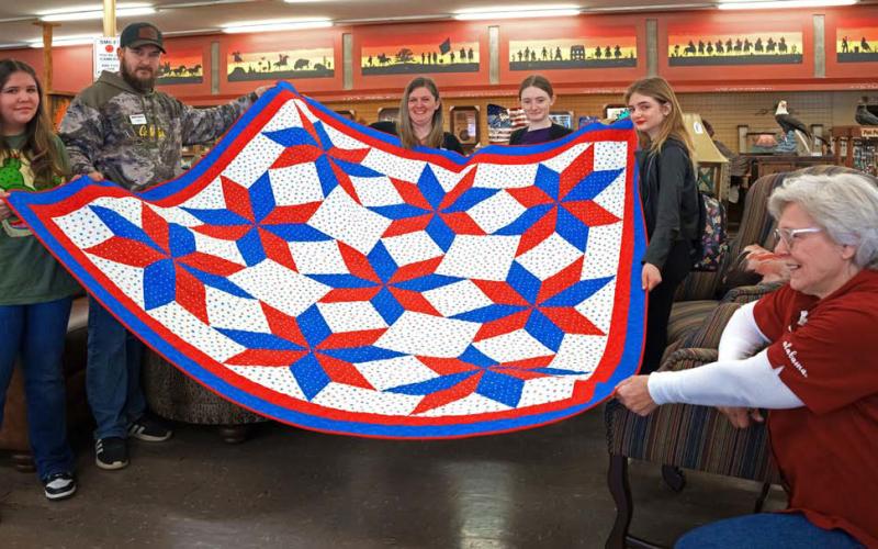 Justin Dupree, second from left, receives a quilt from Bonnie Hammond, at right. He is accompanied by his wife, Tabitha, and daughters Brook, Bailey and Skye.