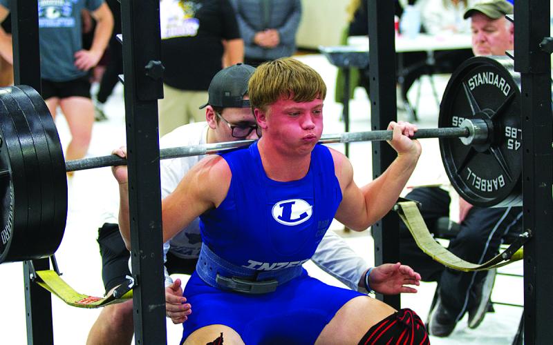 Carter Kuhn squats during the recent home powerlifting meet.