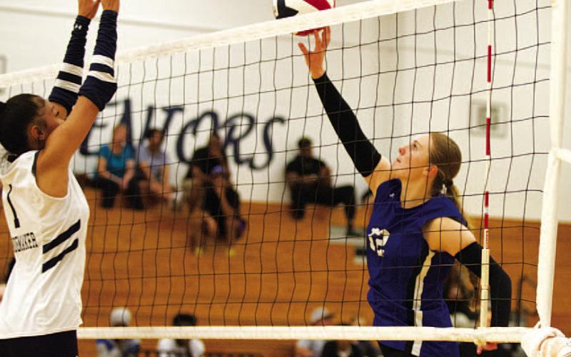Kari Kepler, right, tips a ball over the hands of a Shoemaker player in the Lady Badgers’ win on Tuesday night.