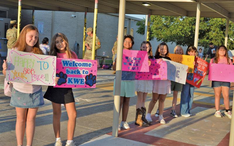 Kline Whitis students, from left, Jentry Jones, Christianna Gonzalez, Nikita Olsen, Kylee Davis, Hazel Cecil, Nadia Martin, Brooklyn Alderson, and Autumn Hiller welcome classmates on the first day of school. erick mitchell | dispatch record