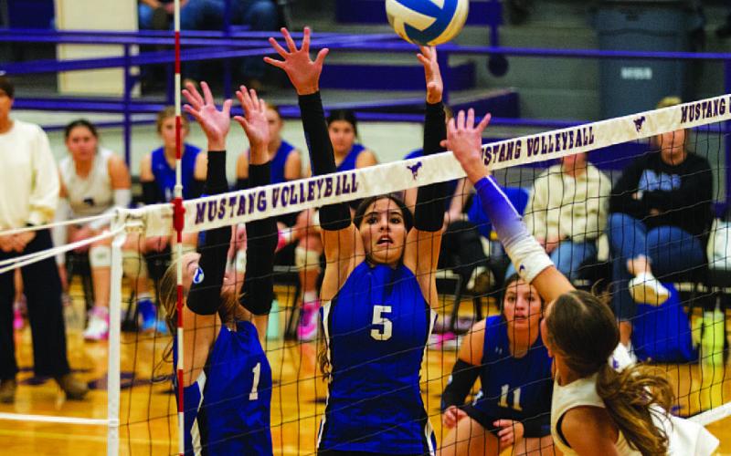 Ysa Swain (5) and Brailey Wilson (1) leap for a block during the Lady Badgers’ match against Marble Falls on Tuesday. HUNTER KING | DISPATCH RECORD