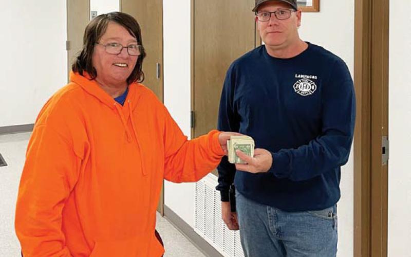 Darlene Cockrell Johnson presents $922 to Lampasas Volunteer Fire Department representative Tim Weinrick. The money, which is to be used to provide toys at Christmas for area children, represents donations collected at two recent fundraisers: an enchilada dinner hosted at the fire station with help from the ladies at Community Kitchen, and a bowling tournament held at Putters &amp;amp; Gutters Fun Center. Johnson thanked the community for its generous donations, auction items and support. courtesy photo